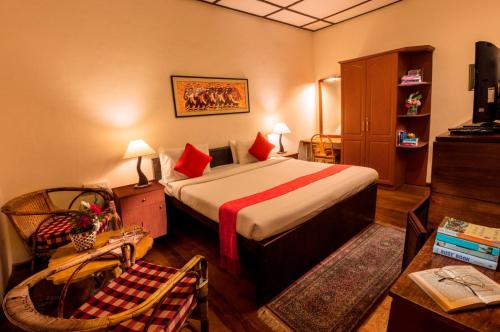 a hotel room with a bed with red pillows at Teanest by Nature Resorts and Stays in Coonoor