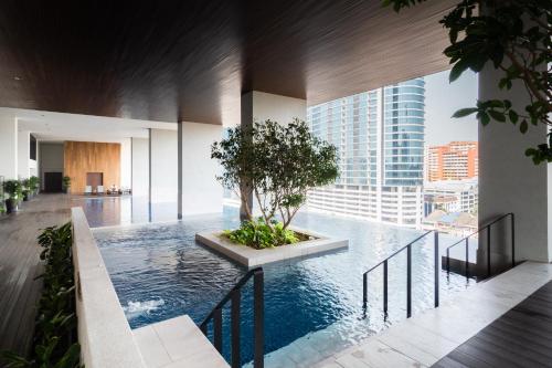 吉隆坡的住宿－EST Suites Bangsar by Airhost，一座享有城市美景的建筑中的游泳池