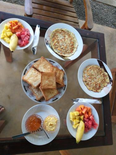 a table with plates of breakfast food on it at Akurala Beach Park in Hikkaduwa