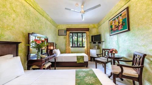 a hotel room with a bed and a desk and a bedroom at Flushing Meadows Resorts & Playground in Panglao Island