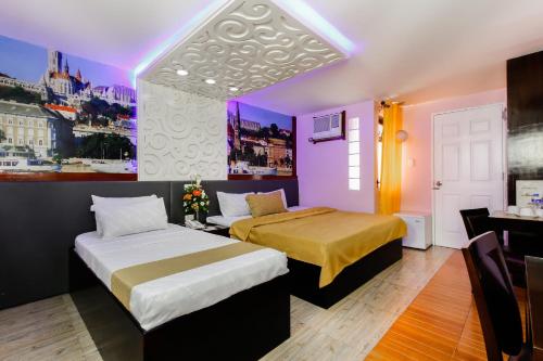 two beds in a room with purple and yellow at Eurotel Baguio in Baguio