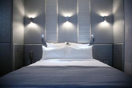 a bedroom with a large bed with two lights on it at L'Adresse in Paris