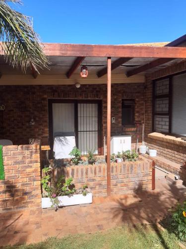 a house with a brick wall and a fence at On Yonder Hill in Cape Town