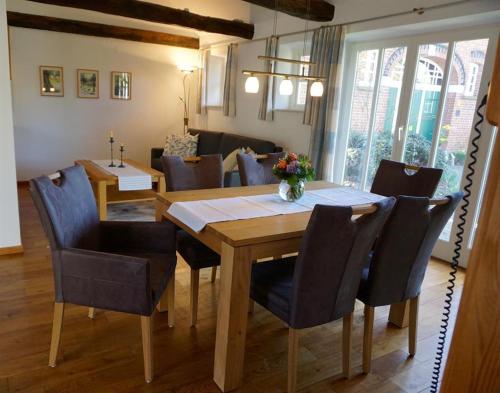 a dining room with a wooden table and chairs at Haus "Am Kienmoor" in Bad Zwischenahn
