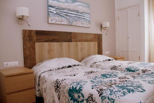 a bedroom with two beds and a picture on the wall at Casa Anna in Caleta De Fuste