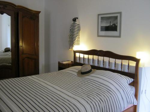 un sombrero sentado en la parte superior de una cama en Maison De Campagne - Porte Brest Ouest., en Guilers