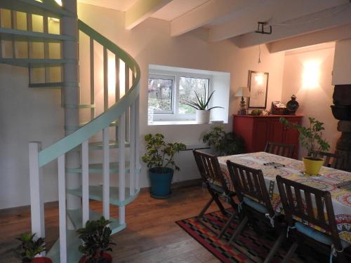 une salle à manger avec une table et un escalier en colimaçon dans l'établissement Maison De Campagne - Porte Brest Ouest., à Guilers
