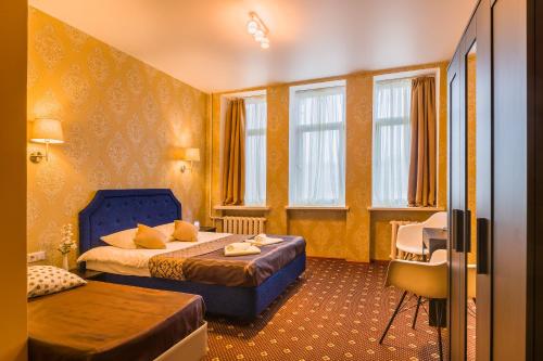 a hotel room with two beds and two windows at Orange Hotel Chistye Prudy in Moscow