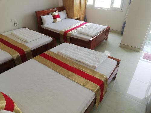 a room with three beds in a room at Hoang Kim Hotel in Vung Tau