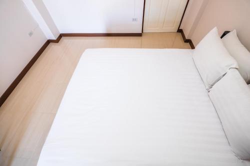 a bed with white sheets and pillows in a room at Don Muang Hotel in Bangkok