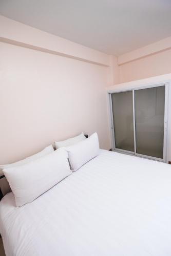 a bedroom with a white bed and a window at Don Muang Hotel in Bangkok