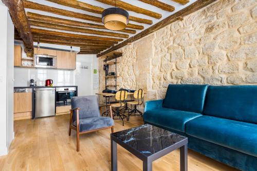 un salon avec un canapé bleu et une table dans l'établissement Peaceful apartment - 1BR-4P - Arts et Métiers, à Paris
