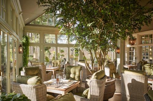 un ristorante con tavoli, sedie e un albero di Cairn Lodge ad Auchterarder