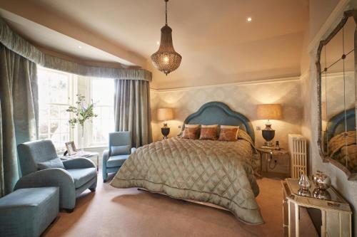 a bedroom with a bed and a couch and a chair at Cairn Lodge in Auchterarder