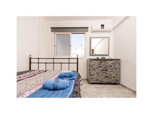 - une chambre avec un lit, une commode et une fenêtre dans l'établissement Holiday Apartment, à Larnaka