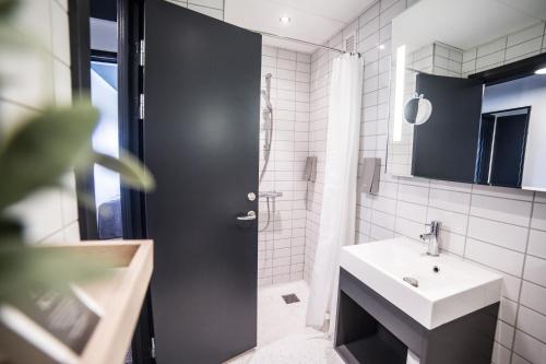 baño con puerta negra y lavamanos en Comwell Roskilde, en Roskilde
