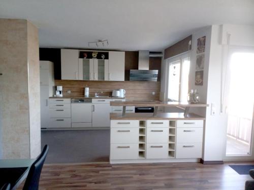 a large kitchen with white cabinets and a sink at Panoramablick vom Obergeschoß in Geislingen an der Steige