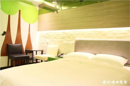 a bedroom with a bed and a desk and a chair at R8 Eco Hotel in Kaohsiung