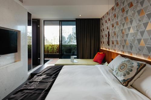 a bedroom with a large bed and a television at CHECK inn Taichung Zhongshan in Taichung