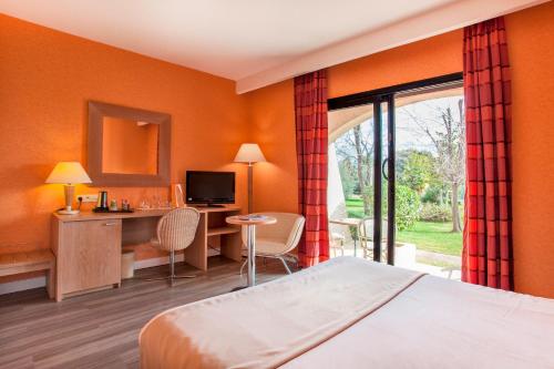ein Hotelzimmer mit einem Bett, einem Schreibtisch und einem Fenster in der Unterkunft Chez Walter in Lucciana