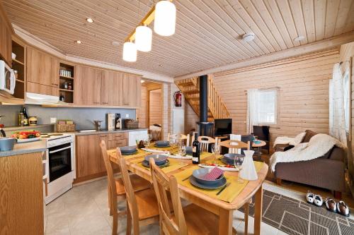 cocina y comedor con mesa de madera y sillas en Luoman Hirvimökit en Ähtäri