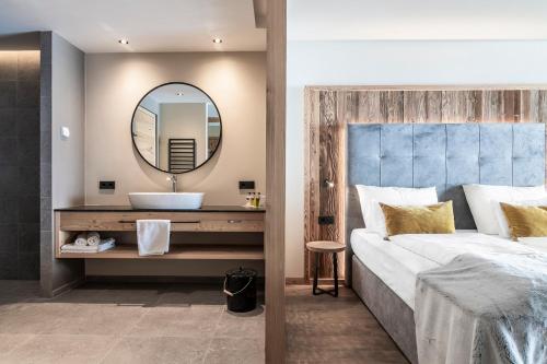 a bedroom with a sink and a large mirror at Sporthotel Sonne in Alpe di Siusi
