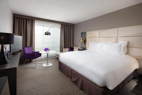 a hotel room with a large bed and a desk at Sofitel Warsaw Victoria in Warsaw