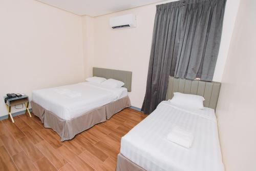 a hotel room with two beds and a window at CREVICE HOTEL in Davao City