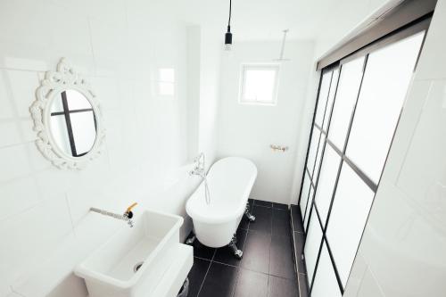 a white bathroom with a toilet and a sink at White Loft Hotel in Melaka