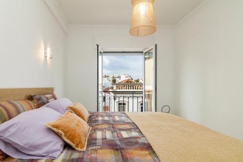 a bedroom with a bed and a large window at Casa EVA Amêndoa in Tavira