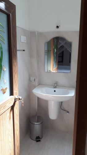 a bathroom with a white sink and a mirror at My Home Resort in Matara