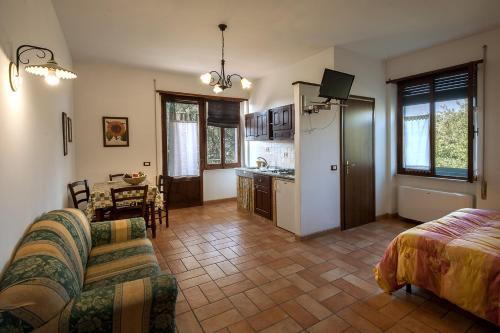 a living room with a couch and a table and a kitchen at Agriturismo Fattoria Poggio Boalaio in Orvieto