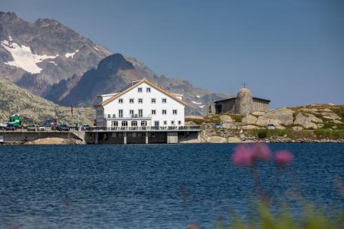 un grand bâtiment blanc au sommet d'un lac dans l'établissement Hotel Grimsel Passhöhe, à Oberwald