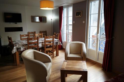 Una sala de estar con mesa y sillas y un comedor. en Duplex spacieux avec vue montagne au cœur de Cauterets, 6 à 8 pers, 3 chambres, 2 SDB, en Cauterets