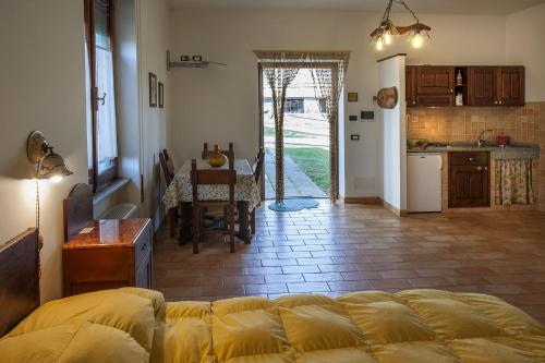 a living room with a couch and a table and a kitchen at Agriturismo Fattoria Poggio Boalaio in Orvieto