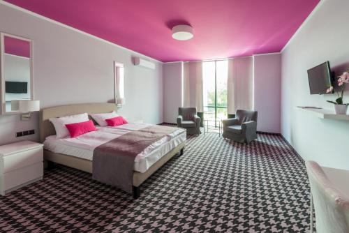 a bedroom with a large bed and a purple ceiling at Hotel Sękowski in Legnica