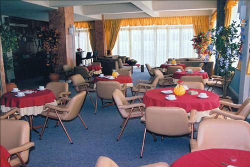 a room with tables and chairs with red table cloths at Ermionida in Kranidi