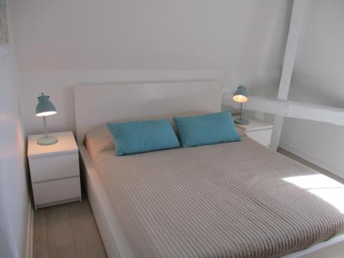 a bedroom with a bed with two pillows and two lamps at Le COURLIS vue panoramique sur la mer, balcons in Ault