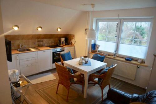 cocina y comedor con mesa y sillas en Tolle Ferienwohnung in schönem Bauernhaus, en Fehmarn