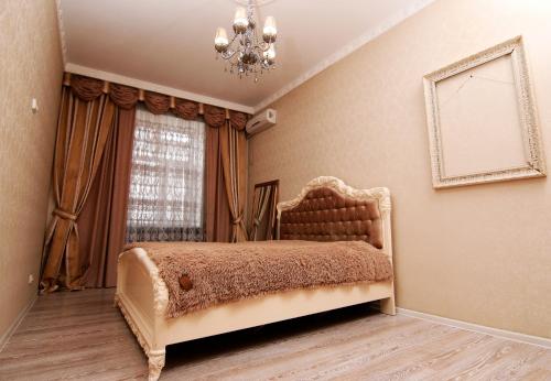 a bedroom with a bed with a chandelier and a window at Апартаменты возле Вокзала, Центр in Dnipro