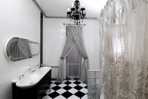a black and white bathroom with a sink and a mirror at Апартаменты возле Вокзала, Центр in Dnipro