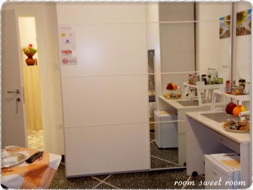 a kitchen with white cabinets and a refrigerator at Room sweet Room in Bologna