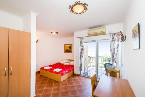 a small bedroom with a bed and a balcony at Apartments Bozana in Zaton
