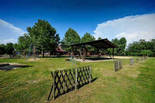 a playground in a park with a wooden fence at Oliver Inn Camping in Balatonlelle