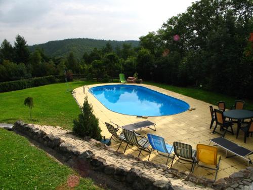 a pool with chairs and a table in a yard at Villa Blanka in Horní Podkozí