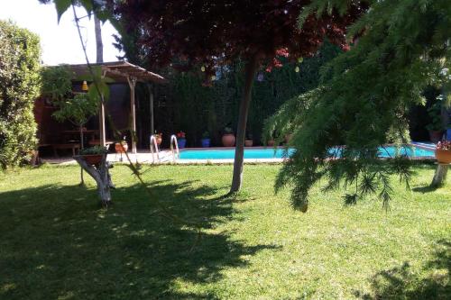 a yard with a swimming pool and trees and a house at Bay Leaves in Jaén