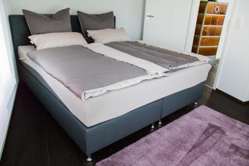 a large bed in a room with a purple rug at Sandras Flat in Giswil