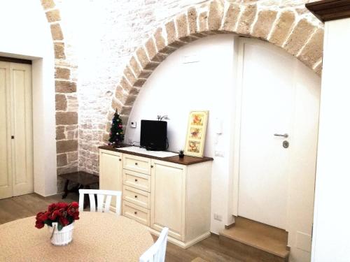 an archway in a room with a table and a tv at Oltre le mura b&b in Bitonto