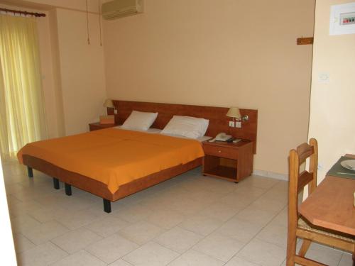 um quarto de hotel com uma cama e uma mesa de cabeceira em Hotel Aki em Loutra Edipsou