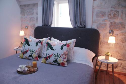 Una cama con almohadas y una bandeja de comida. en Alberto Apartment, en Dubrovnik